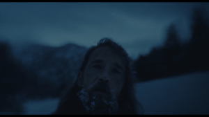 Man looks forward in wintery setting.